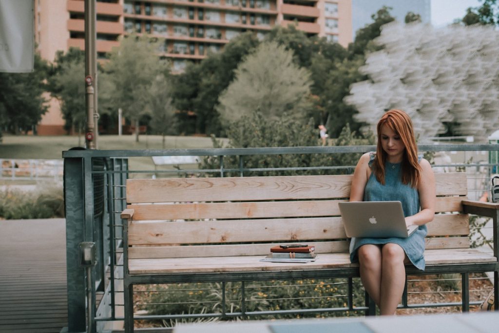 woman working remotely on a bench